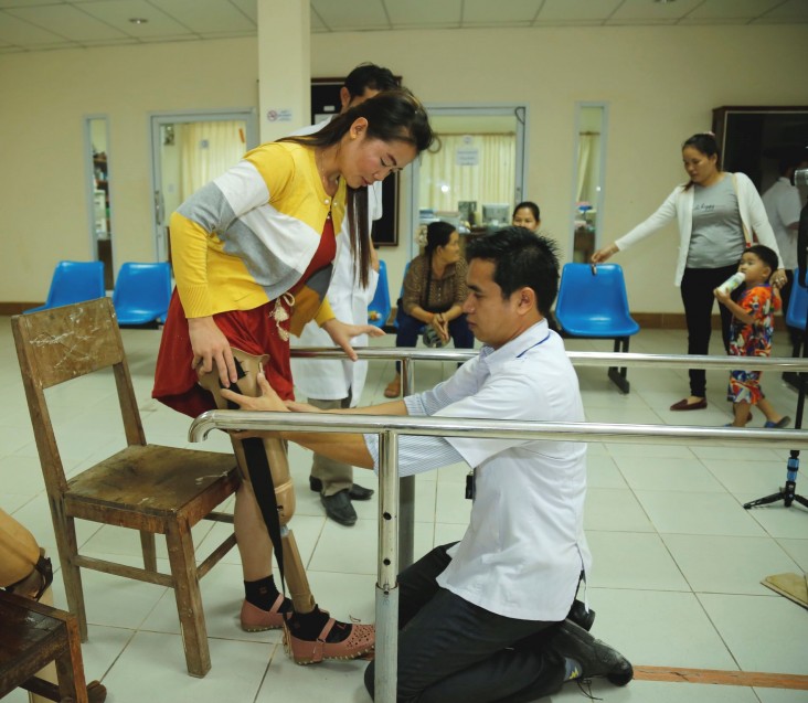 A technician at the Government of Laos’ Center for Medical Rehabilitation measures an artificial leg for a patient.