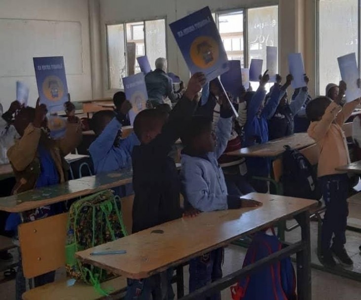 Students at a school im Murzog celebrate the arrival of their textbooks and workbooks in December, 2019.