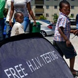A child walking in front of a sign saying Free HIV Testing