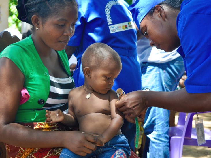 A community health volunteer measures this child’s arm to see if he is meeting his growth targets.