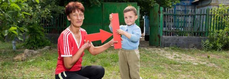 Photo of a mother and son holding a red TB arrow.