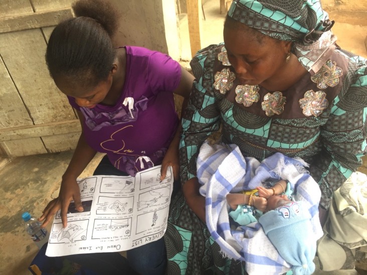 Two young mothers learn how to use chlorhexidine gel with a graphic chart.