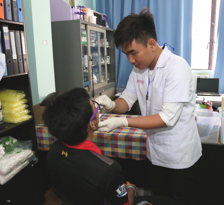 HIV counselor Atachai Phunkron takes an oral swab sample from a client in Bangkok.