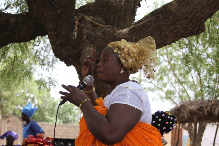 A beneficiary of USAID Women's Empowerment and Civic Journalism project addressing a community in rural Senegal