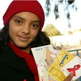 A young woman holds up AIDS Day promotional materials