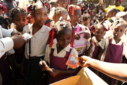 Schoolchildren pick up sachets of oral rehydration salts distributed by USAID/OFDA partner Mercy Corps.