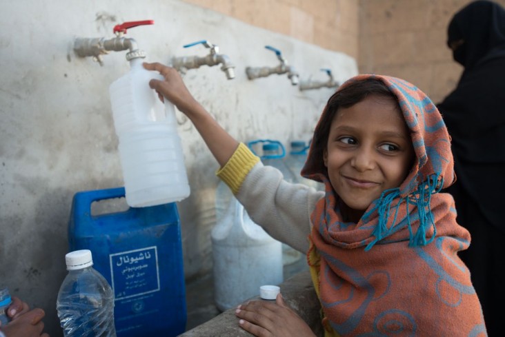 Aaliyah, a 7-year-old IDP, fetches clean water from a newly rehabilitated water.