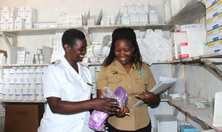 A staff member from a USAID partner organization, right, works with health care workers to determine stock levels of medicines and medical supplies.
