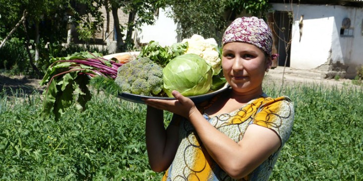 Habiba Tukhtaeva shows off the vegetables she grew in her family's kitchen garden with support from Feed the Future.