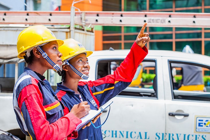  Two female line workers in Nigeria looking up