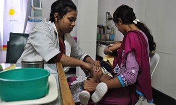 A nurse gives a child an immunization shot
