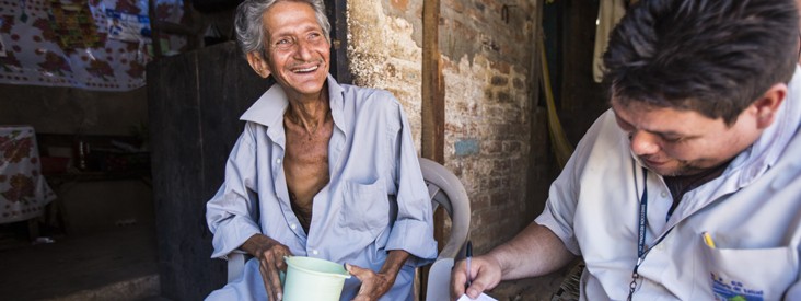 Global Fund - A man and a health worker smile together.