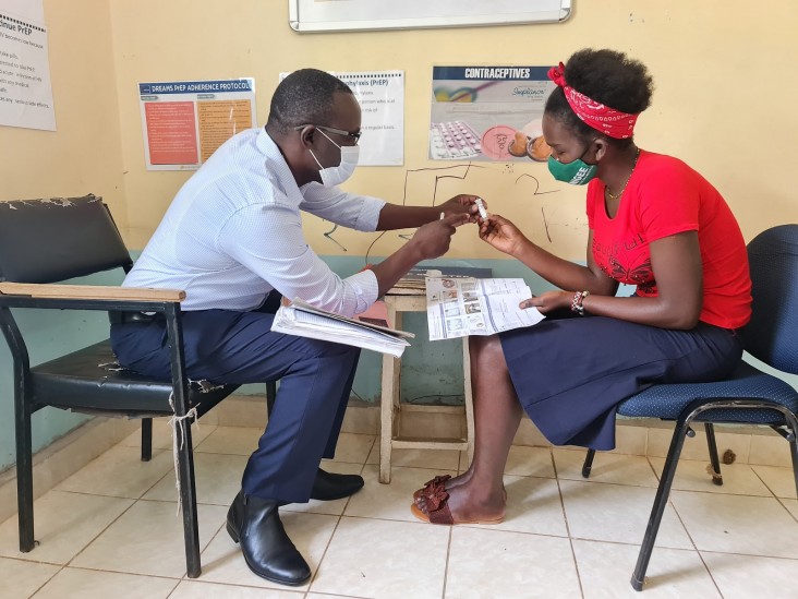 Madiang’ sensitizes a young woman on the use of HIV self-testing at a safe space in Kisumu County.