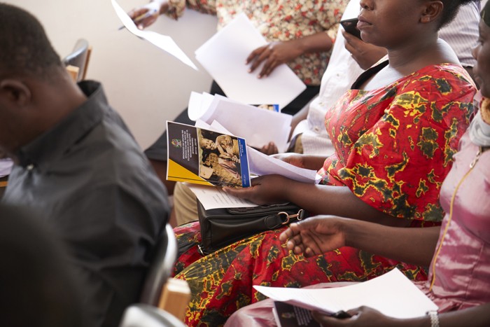 A Violence against Women and Children Committee member holds the National Plan of Action to End Violence against Women and Children in hand as a reference during a recent committee meeting in the Geita region of Tanzania.