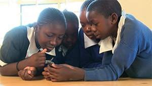 Students in Kenya participate in playing a mobile game that teaches them the importance in making good choices.
