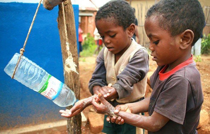 Two children washing their hands in a rural village.