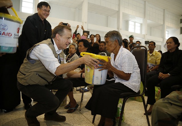 U.S. Ambassador to Thailand Glyn T. Davies helps hand out supplies in Nakhon Si Thammarat, Thailand to residents affected by recent flooding.