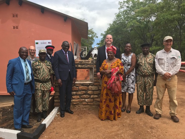 Zambia Minister of Tourism Charles Banda (center left) and U.S. Ambassador Daniel L. Foote (center right) join wildlife police, community leaders, and USAID program partners at unveiling of the refurbished Mukamba Gate Complex.