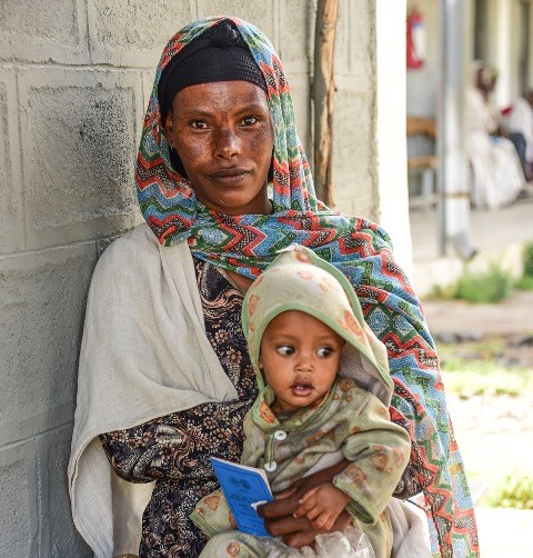 Image of Ethiopia mother and child with community health insurance card.