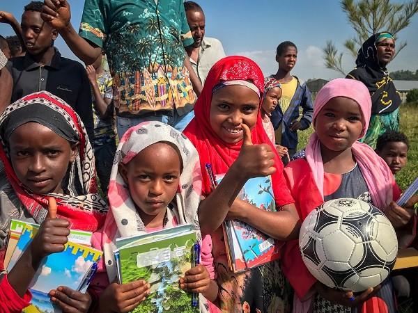 Image of Ethiopian school children receiving learning materials.