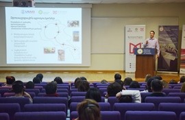 Man presents on stage during training for guides.