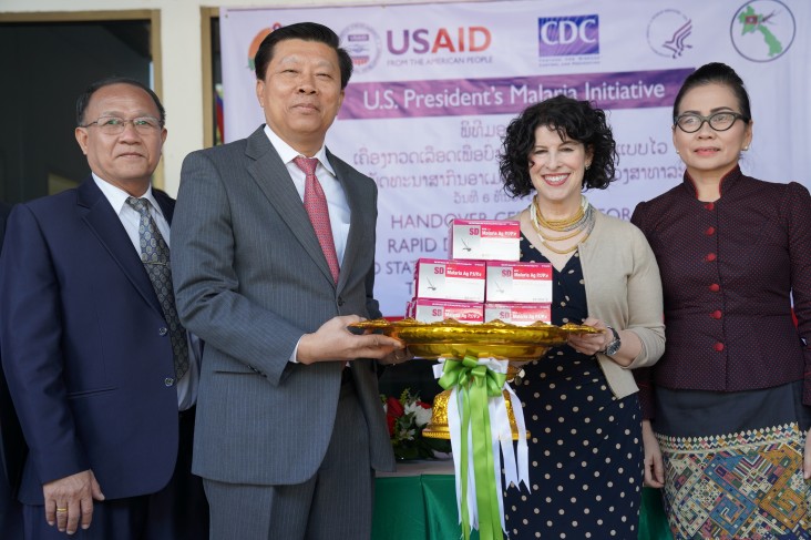 Dr. Phouthone Muoangpak (center left), Vice Minister of Health, receives 100,000 rapid diagnostic test kits from U.S. Ambassador to Laos Rena Bitter (center right) at a handover ceremony in Vientiane on December 6.