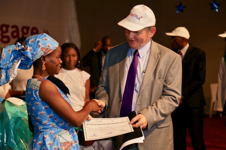 Ambassador Dennis B. Hankins providing certificate to a beneficiary