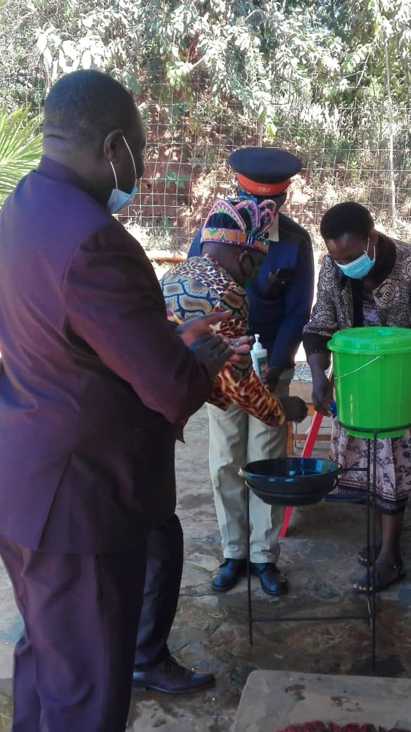 USAID DISCOVER Health’s Kelly Chanika (left) demonstrates proper handwashing techniques with Chief Kanyama (center) and Senior Chief Sailunga (right) in Mwinilunga district, North Western Province, during one of the COVID-19 sensitization training sessions with traditional leaders.