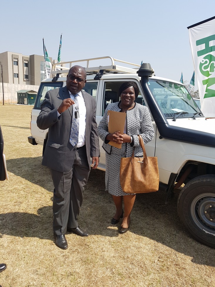 Minister Chilufya receives a set of car keys from Dr. Musumali after the handover of five 4x4 vehicles to assist the Ministry of Health’s expansion of maternal and child services across Zambia.
