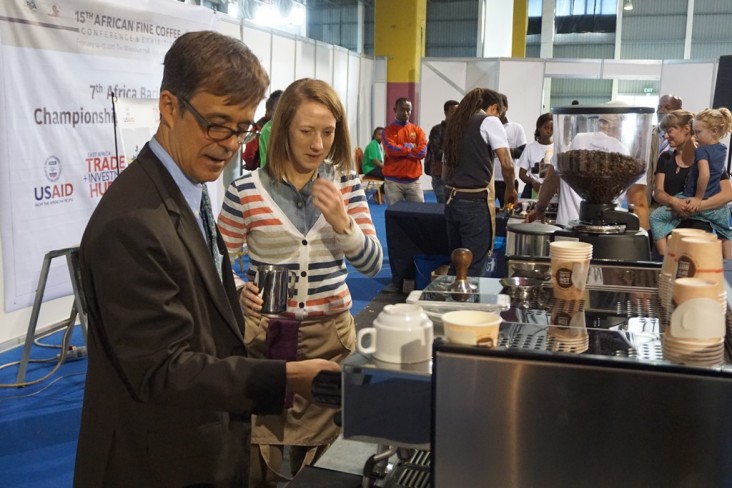 U.S. Chargé d'affaires to Ethiopia Peter Vrooman tries his hand as a barista at the 7th Africa Barista Championship & All Star Challenge booth. The booth is sponsored by USAID’s East Africa Trade and Investment Hub.