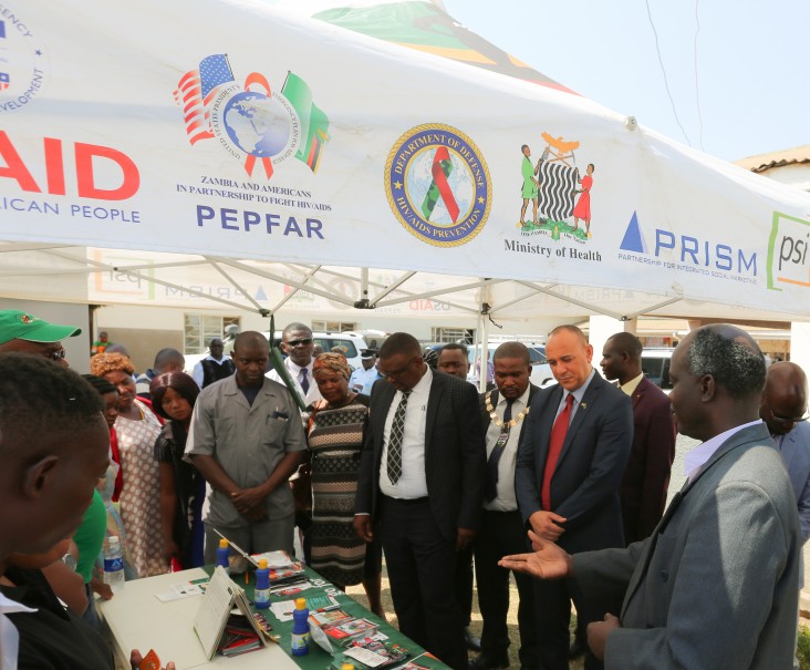 Chargé d'affaires Martin Dale (center right) visits a Ministry of Health's booth after officially handing over the nineteen solar-power systems to the Ministry of Health.