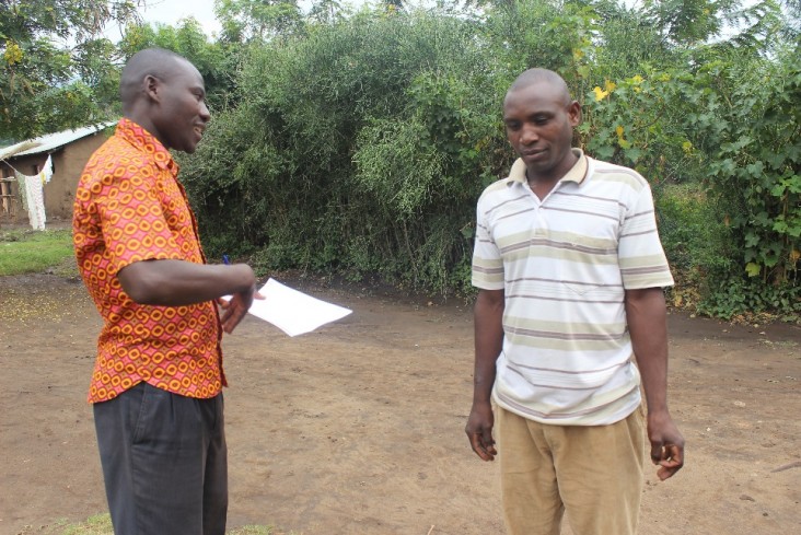 Two Men Discuss Malaria prevention in Uganda