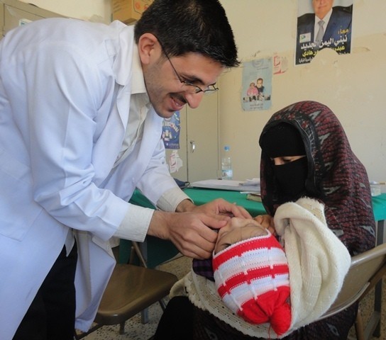 A physician examines an infant in the Amran governorate in northern Yemen. The doctor is part of a USAID-sponsored mobile medical team that travels to areas lacking proper medical care.