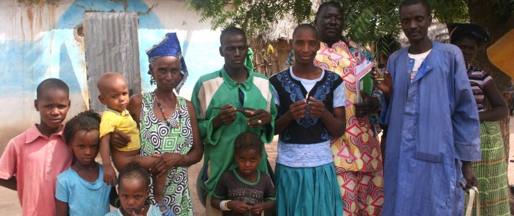 Rougui Diallo’s family poses for a photo with two community health workers, at right, after a home visit.