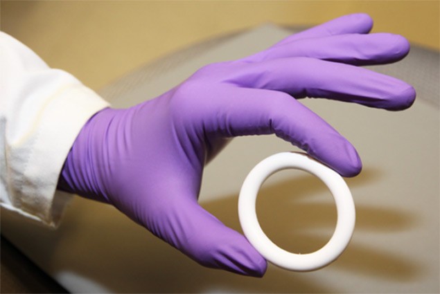 Photo of a purple-gloved hand holding a vaginal ring