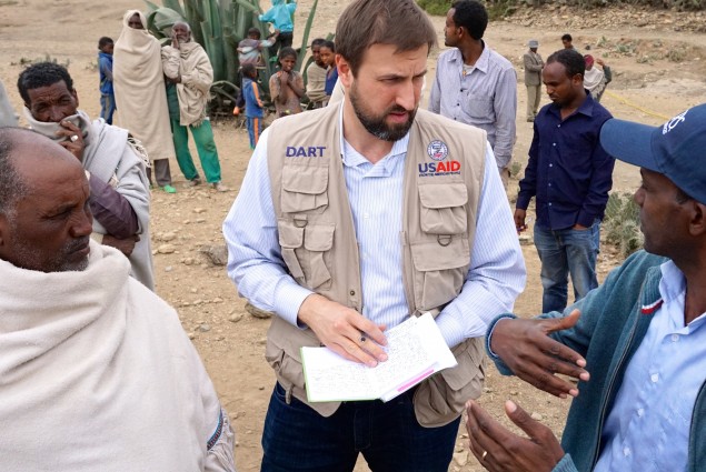USAID Office of Foreign Disaster Assistance Director Jeremy Konydnyk discusses how Ethiopia's drought is affecting residents in the Enderta Woreda of Tigray Region. A Catholic Relief Services representative (right) is explaining how the current well rehabilitation will help alleviate the suffering by community members.