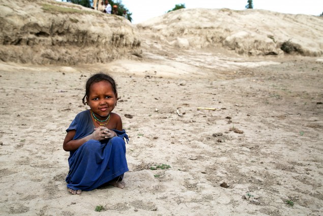 This little girl sits at the bottom of a basin that used to be a watering hole for an entire community of about 30 families. Her hands and feet are covered with a thin film of powdery gray silt, just like all the village children. There's no water to even wash it off.