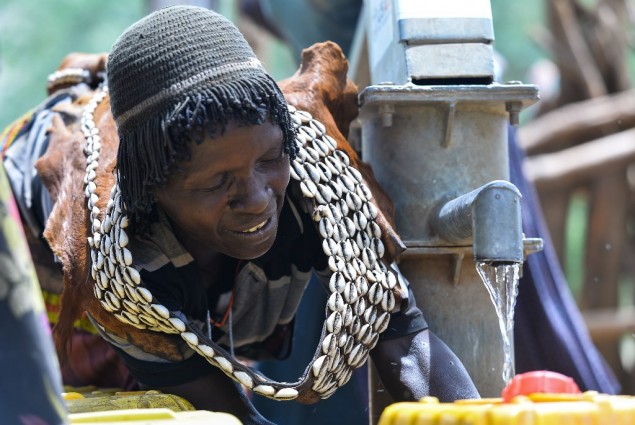 Image of woman in Ethiopia filling water jugs