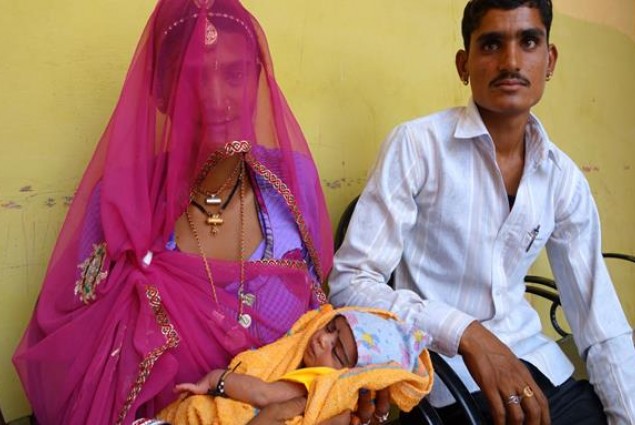 A father and mother with their newborn child in India