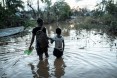 Rosita Moises Zacarias (L), 15, holding the hand of her sister Joaninha Manuel, 9, walks in flooded waters from their house destroyed by the cyclone Idai, to go to seep in a shelter in Buzi, Mozambique, on March 22,