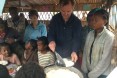 Ambassador Lane participates in a WFP school canteen while FFP Dina Esposito looks on
