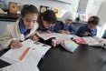 Young girls are hard at work studying history a USAID-funded school.