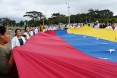 Venezuelan doctors hold a giant Venezuelan flag during a protest against the government of President Nicolas Maduro at the Tienditas International Bridge, which is blocked by the Venezuelan military.