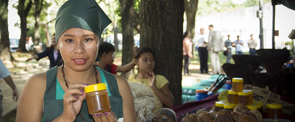 Indigenous woman selling honey at a local market - Credit: Teresa Torres for USAID