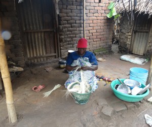 Asha Goa works outside her house in Tanzania.