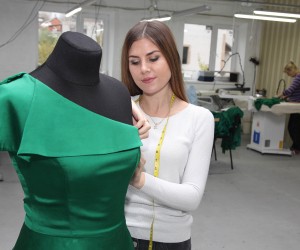 Kateryna Kyselyova, an internally displaced person from Horlivka, Donetsk Oblast, designs a dress at the design company she owns.