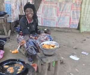 Nigerian women sits near goods for sale