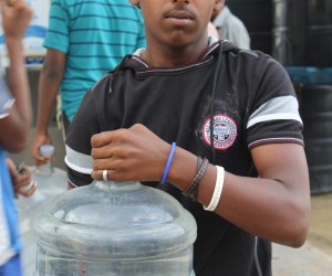 A slum dweller in Bangalore’s Lingarajpuram district holds a can of purified water.