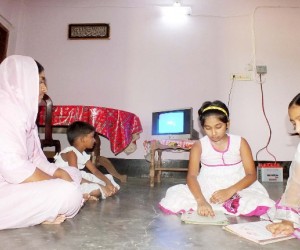 Tania Khatun and her children enjoy watching the solar-powered television. 