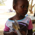 Robert, 2, eats high-energy biscuits after arriving in Uganda